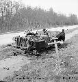 The grave of a British soldier who was killed during Operation Market Garden in 1944, lies alongside the wreckage of his jeep near Arnhem, 18 April 1945.