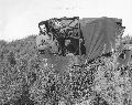 Hospital Apprentice First Class R. D. Glover, Navy corpsman serving with the Marines, rides a USMC jeep ambulance bringing a wounded Marine from the line on maneuvers somewhere in the South Pacific, c