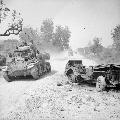 A Stuart tank, crewed by members of the 19th Indian Division, passes a destroyed jeep on the outskirts of Mandalay shortly after the fall of Fort Dufferin, 19 March 1945. IWM photo
