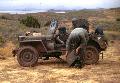 US servicemen during training/maneuvers with a jeep equipped with wire-laying reel. Probably taken a